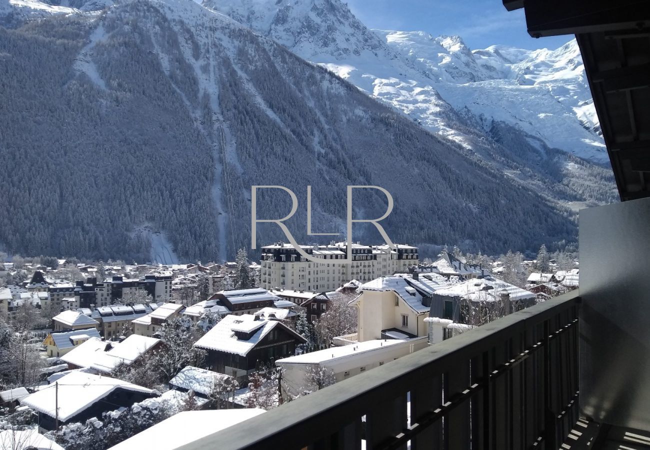 Brevent 1 a un balcon avec table de café et chaises et une vue sur Chamonix et le Mont Blanc
