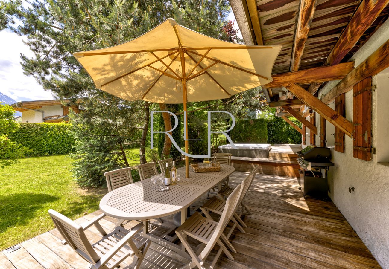 Terrasse du Chalet les Sauberands orientée au sud avec barbecue, hot tub et vue impressionnante sur les montagnes.