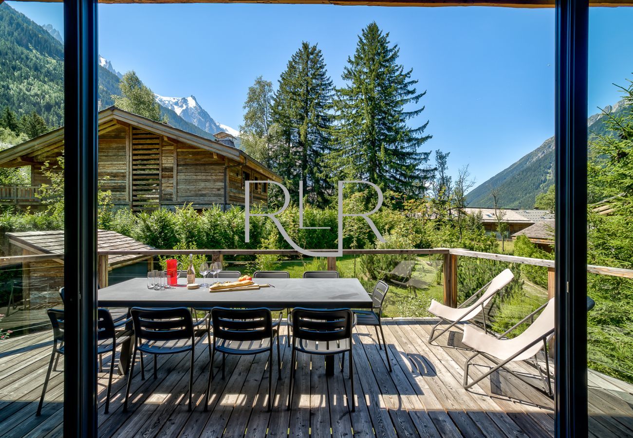 Chalet Black Stone a des portes vitrées donnant sur un balcon ensoleillé
