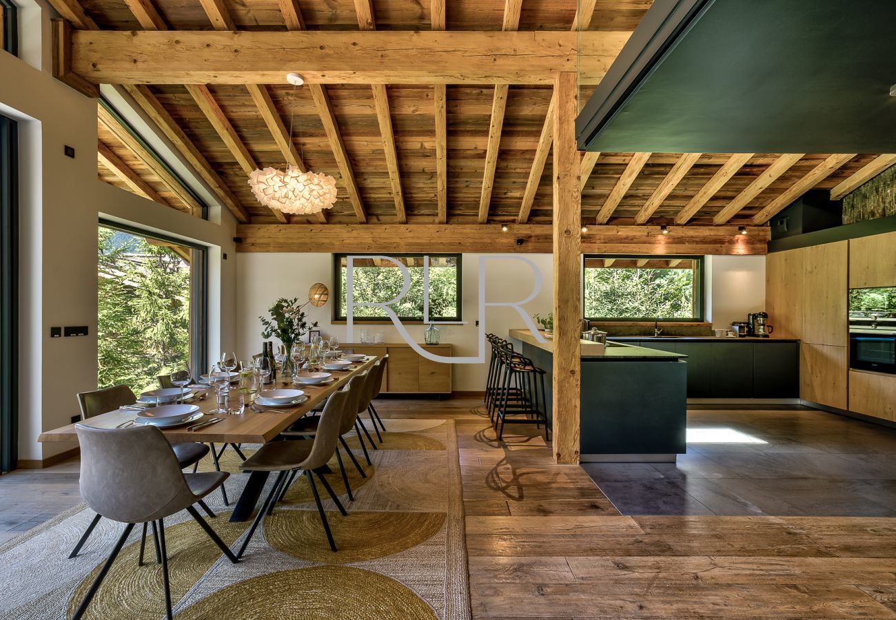 Chalet Black Stone a une table à manger pour 10 personnes, devant les portes vitrées donnant sur le balcon