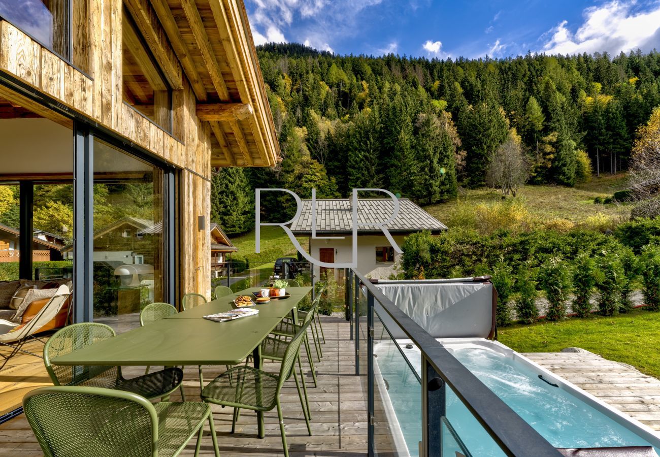 Chalet les Côtés du Lavancher a un balcon avec mobilier de salle à manger donnant sur le grand jacuzzi.
