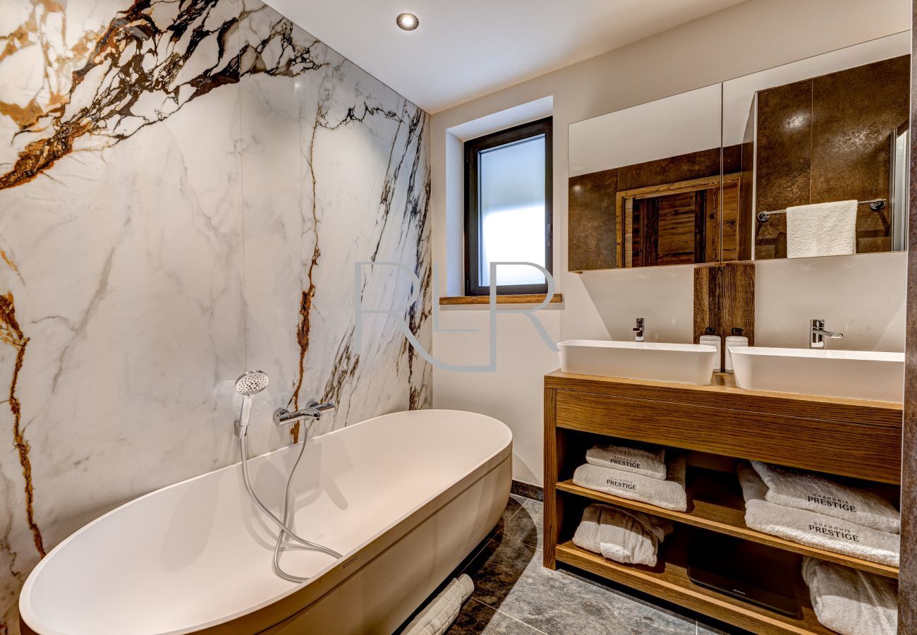 Chalet les Côtés du Lavancher  a une magnifique salle de bain à Chambre 1 avec une baignoire design.
