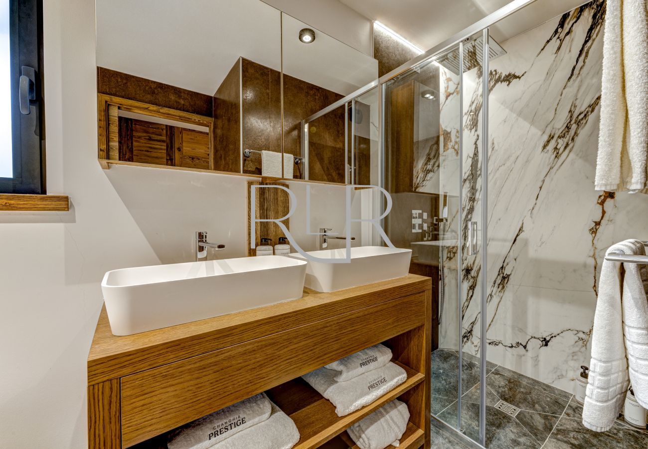La Salle de bain de Chambre 1 de Chalet les Côtés du Lavancher est avec deux lavabos et douche, WC séparé.