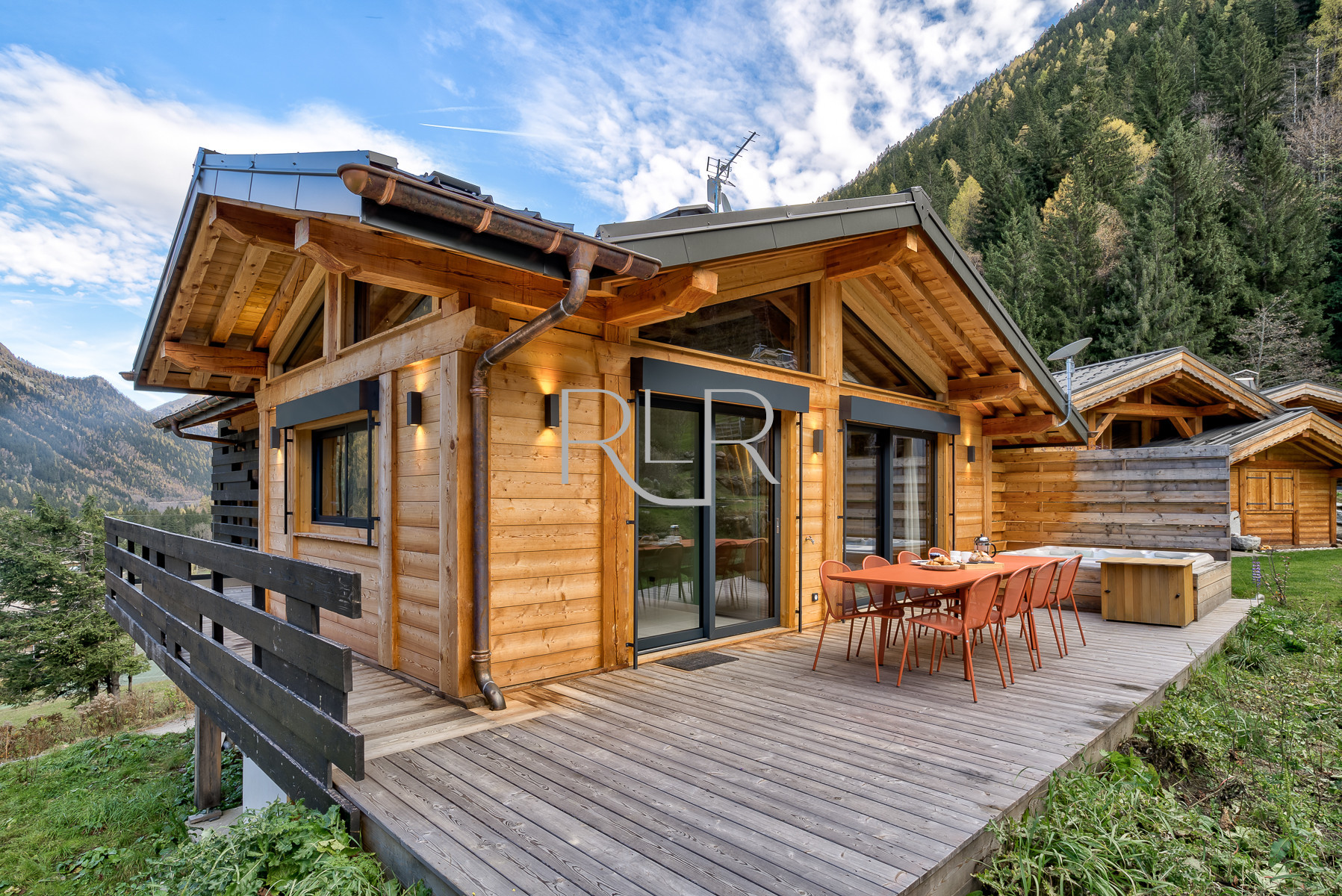 Chalet Green Forest has a deck with outdoor dining furniture and hot tub