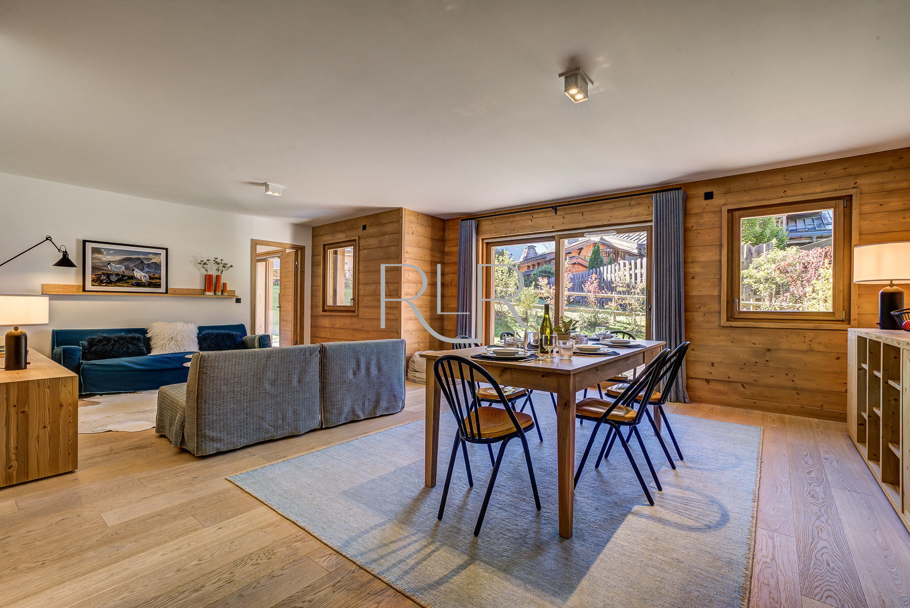 The dining table in Green 2 sits in front of large glass doors