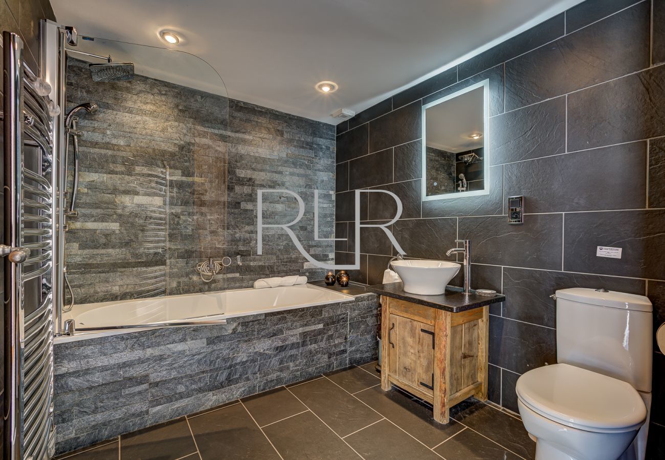 Chalet Capricorne has a bathroom with a shower above the bath