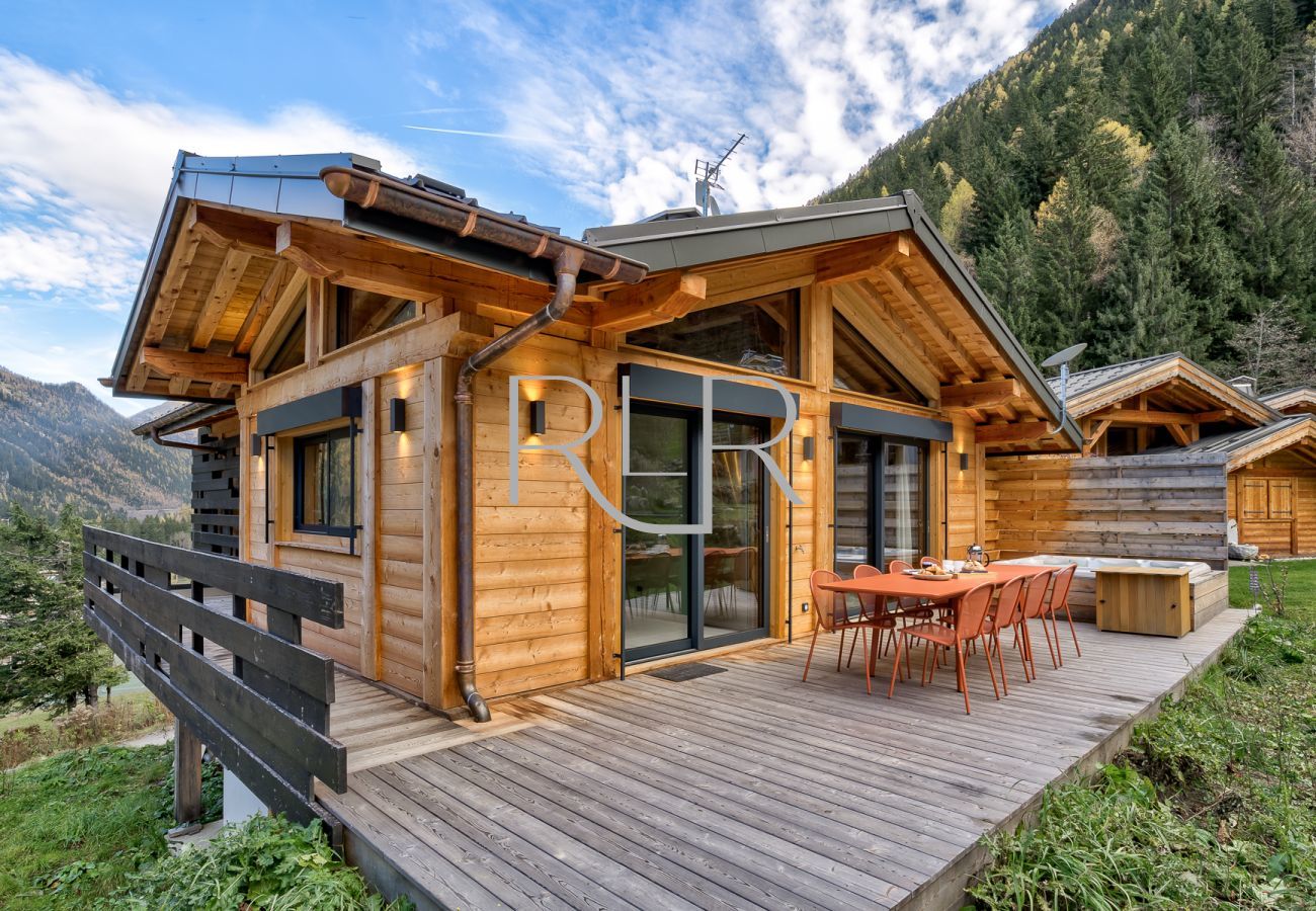 Chalet Green Forest has a deck with outdoor dining furniture and hot tub