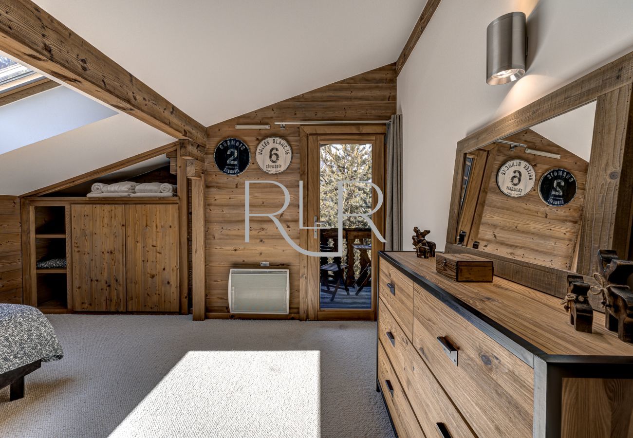 Neatly designed Bedroom 5 in Chalet les Sauberands leads out onto a balcony. 