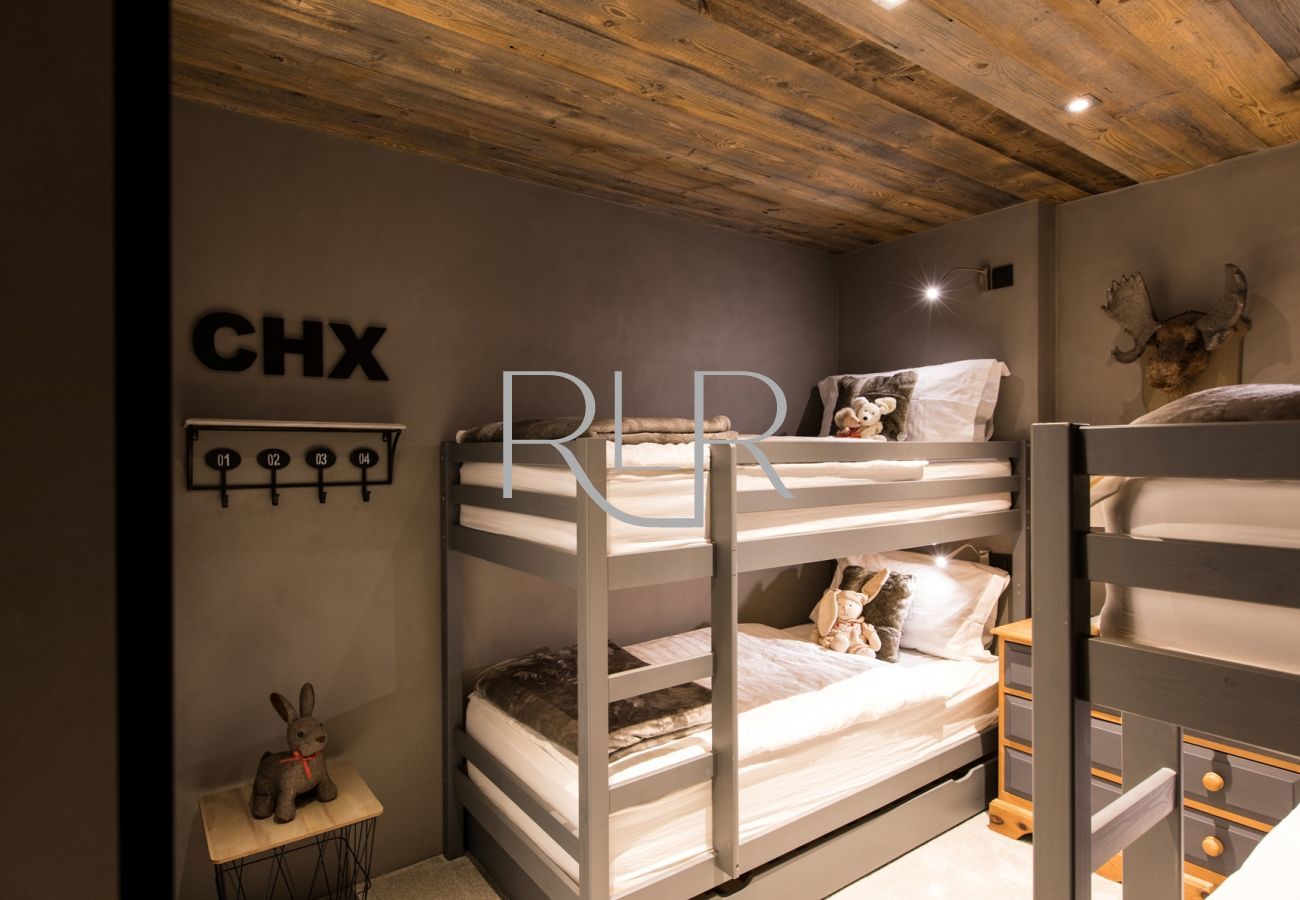 Bedroom 5 of Chalet Seren has two sets of bunk beds, with an ensuite shower room with a WC
