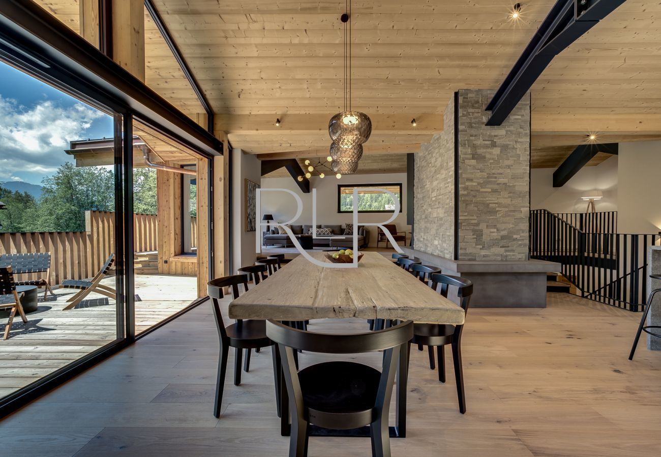 The dining table of Chalet Breitalps is positioned infront of the large, glass sliding doors