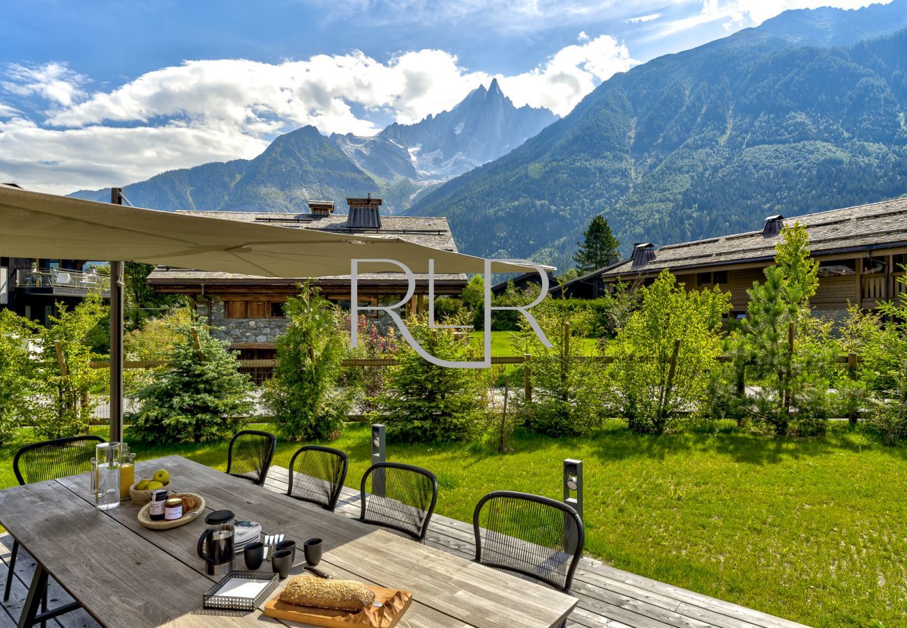 Chalet les Trois Soeurs has outdoor dining furniture and a large parasol  
