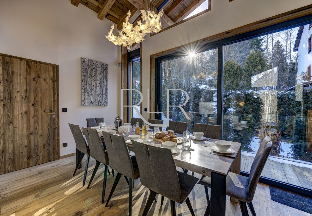 Chalet Silver Forest has a dining table for 10 people beside glass doors onto a balcony with BBQ
