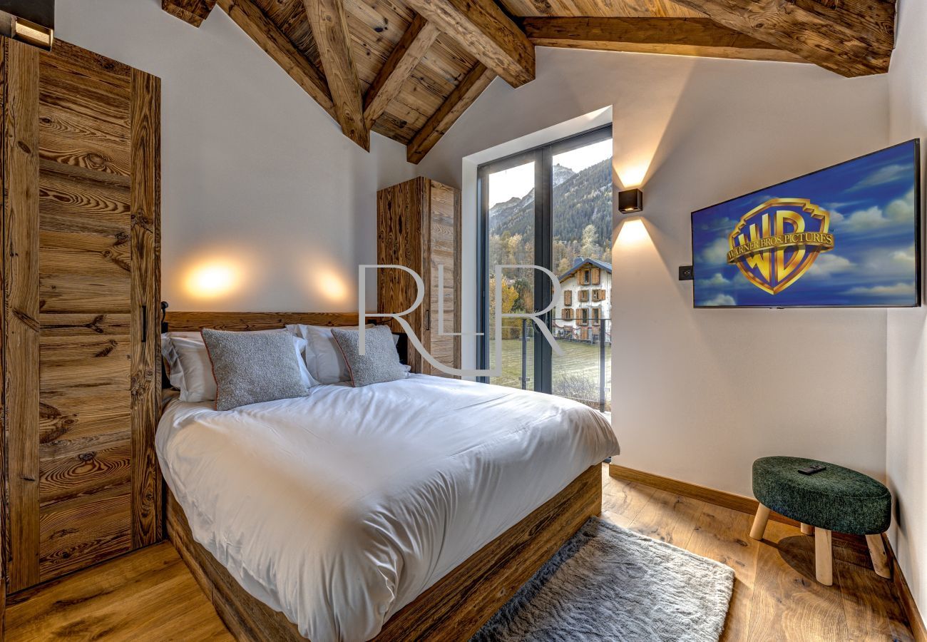 Bedroom 5 of Chalet les Côtés du Lavancher has glass doors onto a balcony.